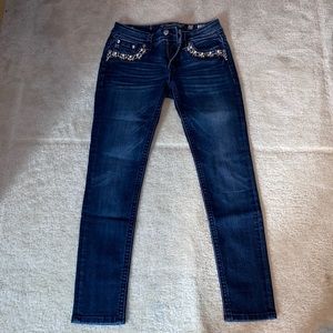 Miss Me mid-rise skinny jeans with pearl and jewel pockets.